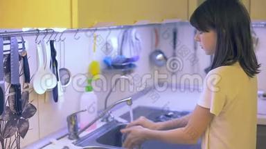 少女在水槽里洗碗，<strong>帮</strong>忙<strong>做家务</strong>。